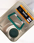 Top of metal tin with green handle, pouring spout, and 'koroni' olive oil sticker.