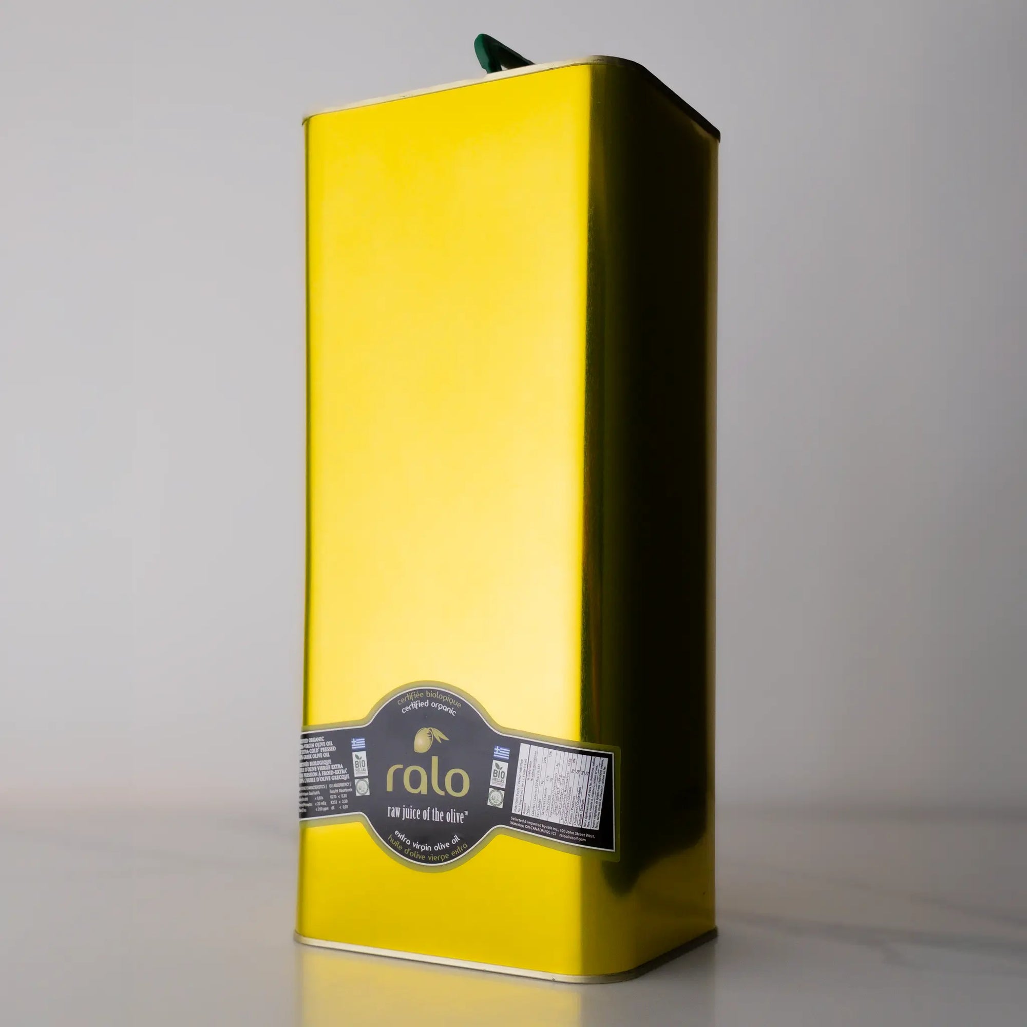 Yellow olive oil tin with a label on a gray background